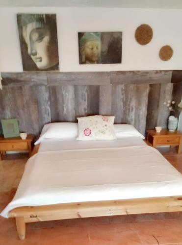 a bed in a room with pictures on the wall at Sophisticated Villa in Sant Josep de sa Talaia with Private Pool in Sant Josep de Sa Talaia
