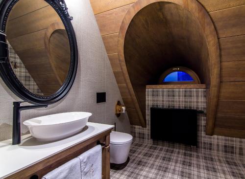 a bathroom with a sink and a toilet and a mirror at Willa na Kozińcu in Zakopane