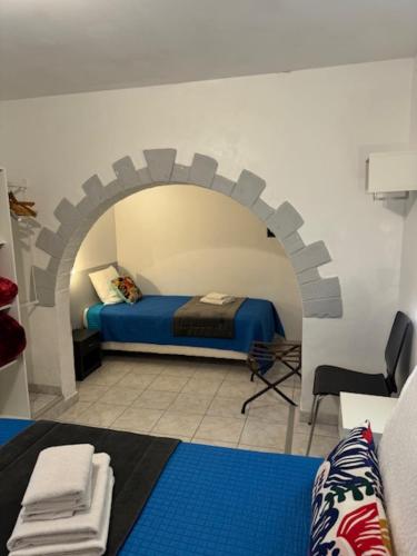 a bedroom with a bed with an arch in the wall at LOGIS Hôtel La Chaumière in Marseillan