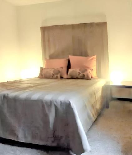 a bedroom with a large bed with pink pillows at Spacious house with garden in Comblain-au-Pont in Comblain-au-Pont