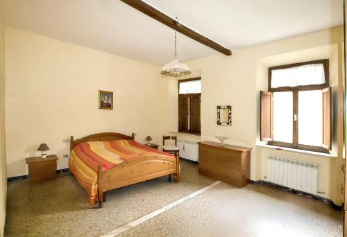 a bedroom with a bed and a desk and a window at Charming Apartment in Massa Marittima, Shared Pool in Massa Marittima