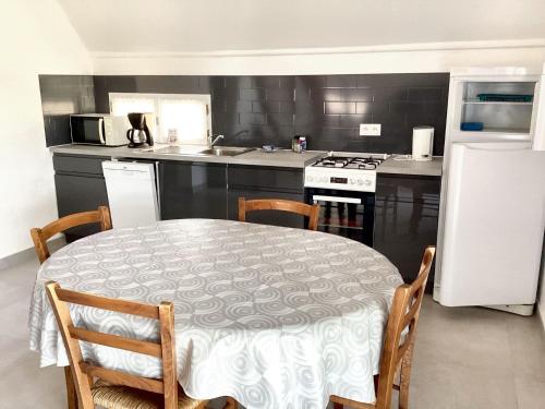 una cucina con un tavolo, un fornello e un frigorifero di Maison conviviale avec jardin à Saint-Nazaire-de-Pézan a Saint-Nazaire-de-Pézan