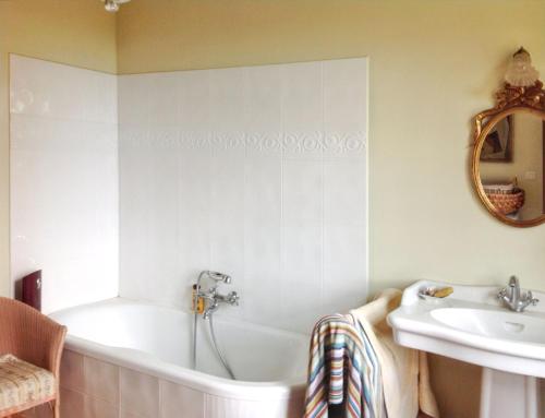 ein Badezimmer mit Badewanne und Waschbecken in der Unterkunft Grande Villa à Villeneuve-sur-Lot avec Piscine Privée in Villeneuve-sur-Lot