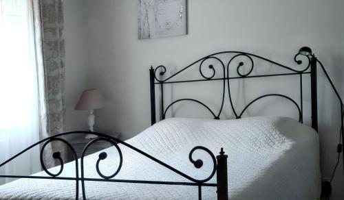 a bedroom with a black metal bed with white sheets at Charmante villa à Dauphin avec piscine privée et jardin in Dauphin
