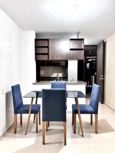 a kitchen with a dining table and blue chairs at Apartamento colonial en Girón in Girón