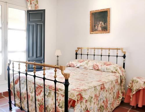 een slaapkamer met een bed met een bloemenbed bij Charming House in Castilblanco with Terrace and Fireplace in Castilblanco