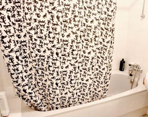een badkamerdouchegordijn met een zwart-wit patroon bij Charming House in Castilblanco with Terrace and Fireplace in Castilblanco