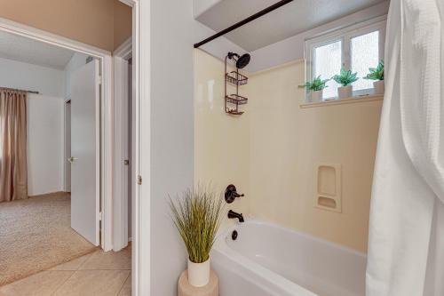 a white bathroom with a tub and a window at 4 Mi to Salt River Mesa Home with Private Patio in Mesa