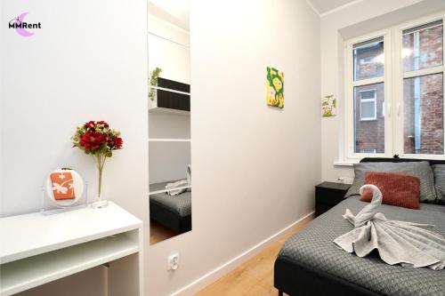 a small bedroom with a bed and a mirror at MMRent Mystic Room in Gdańsk