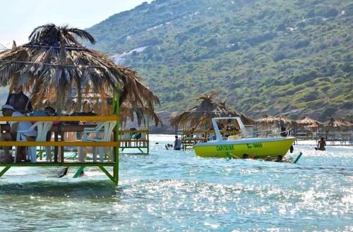 a yellow boat in the water next to a beach at Ghar el melh in Ghār al Milḩ