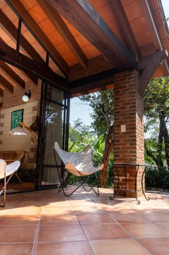 a patio with a white chair and a table at Charming cabin with Scenic view in Tepoztlán in Tepoztlán