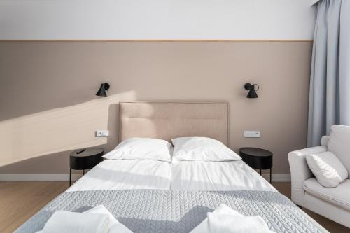 a bedroom with a bed and a couch at FARO Apartamenty Polanki Aqua SPA Deluxe 4 baseny w cenie, Pools inklusive in Kołobrzeg
