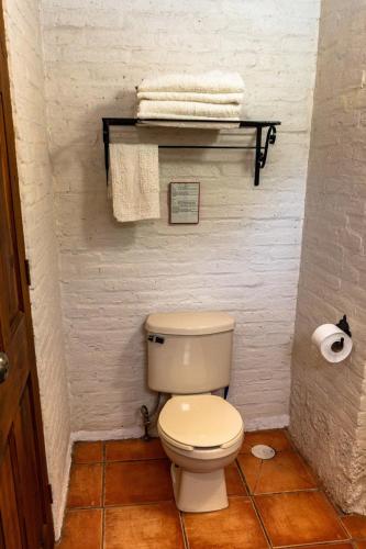 a bathroom with a toilet and towels on a shelf at Charming cabin with Scenic view in Tepoztlán in Tepoztlán