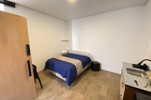 a bedroom with a bed and a sink in it at Studiohaus Pertence in Sao Paulo