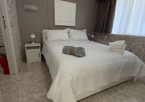 a bedroom with a large white bed and a window at Stone House in Taranto