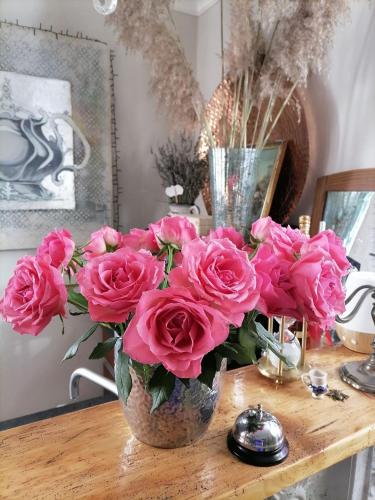 a vase filled with pink roses on a table at CASA BELGERI - Bed & Breakfast in Dongio