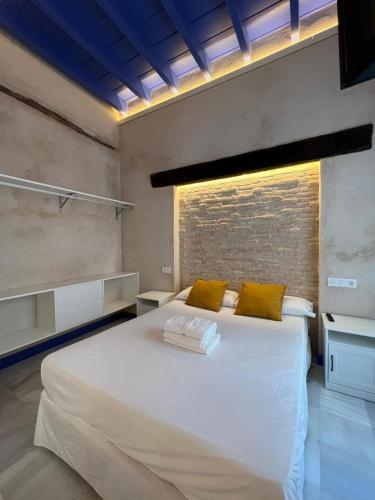 a bedroom with a large white bed with yellow pillows at Philippe's Home Triana in Seville