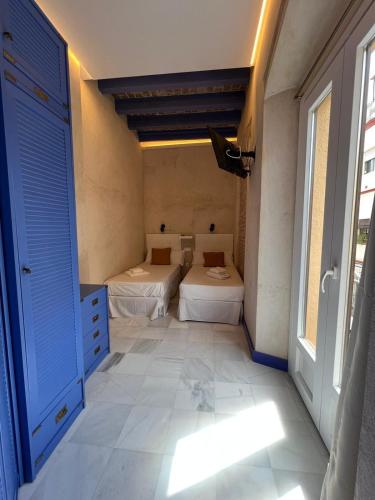 a room with two beds and a window at Philippe's Home Triana in Seville