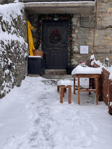 a door of a house with a table in the snow at la foret in Metsovo