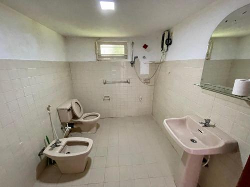 a bathroom with a toilet and a bidet and a sink at Casa Del Ceylon in Hikkaduwa