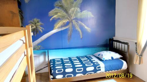 1 dormitorio con 1 cama y un mural de palmeras en Maison familiale avec piscine partagée à Moissac, jardin, en Moissac