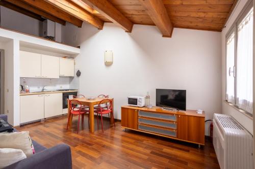 a living room with a table and a kitchen at Casa Petrucci centro storico in Forlì