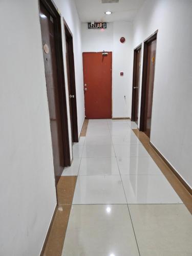 a corridor of a building with a red door at Asia Hotel by AeCOTEL in Sandakan