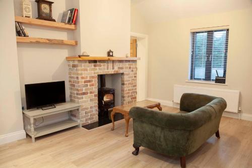 a living room with a couch and a fireplace at Lavender Cottage - 2 Bedroom Home in Newbridge