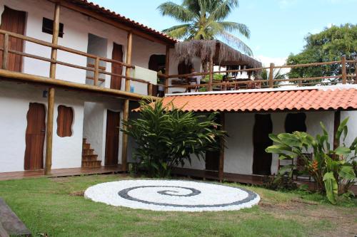 a house with a large target in the yard at Pousada Cavallitos d'Amar in Ilha de Boipeba