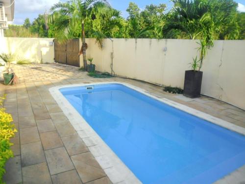 a swimming pool in a yard next to a fence at Paradisiacal Villa in Grand Baie with Private Pool in Grand Baie