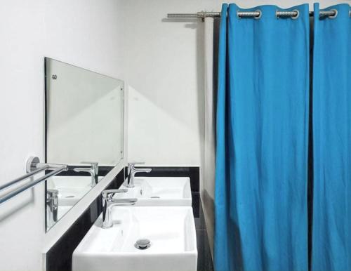 a bathroom with two sinks and a blue shower curtain at Paradisiacal Villa in Grand Baie with Private Pool in Grand Baie