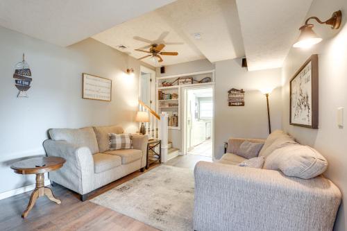 a living room with two chairs and a ceiling fan at Cozy Table Rock Lake Boathouse with Pool Access in Cape Fair