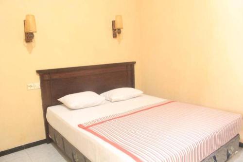 a bed with two pillows on it in a room at Surya Guest House in Kanigaran