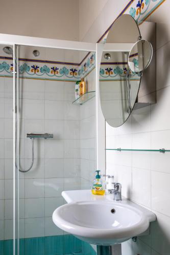 a white bathroom with a sink and a mirror at Casa Petrucci centro storico in Forlì