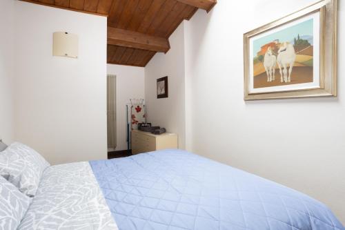 a bedroom with a bed and a painting on the wall at Casa Petrucci centro storico in Forlì