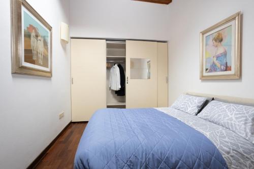 a bedroom with a blue bed and a closet at Casa Petrucci centro storico in Forlì