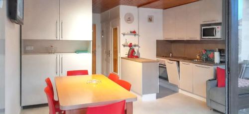 レ・キャローズ・ダラッシュにあるStudio accueillant à Les Carroz, 27 m², vue montagneのキッチン(テーブル、赤い椅子付)