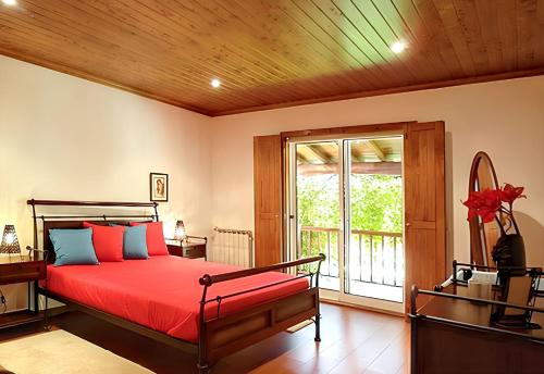 una camera da letto con un letto rosso e una finestra di Elegant Villa with Panoramic Views in Caniçada a Caniçada