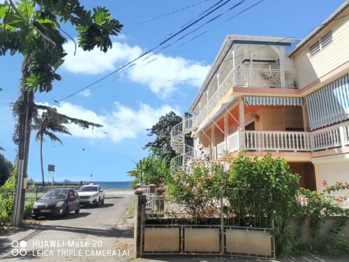 Appartement confortable avec vue sur mer à Deshaies, 48 m² في ديساي: منزل على جانب شارع مع المحيط