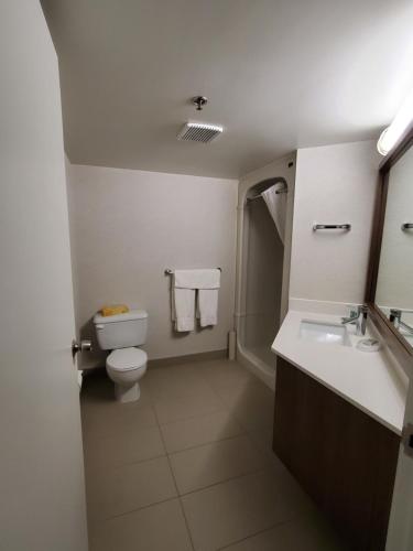 a bathroom with a toilet and a sink at Best Western Hotel Brossard in Brossard