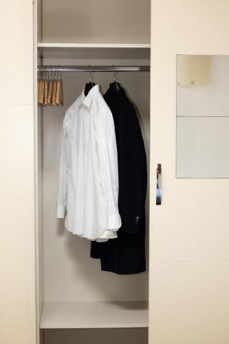 a closet with a white shirt and black clothes at Casa Petrucci centro storico in Forlì