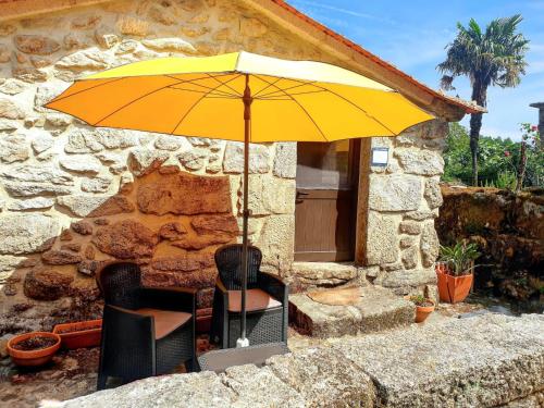 a yellow umbrella sitting in front of a building at Cozy studio with mountain view - 20 m² - Águeda in Urgueira