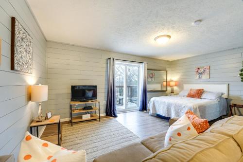 a bedroom with a bed and a tv and a couch at Hike, Boat, Fish and More Table Rock Lake Cottage in Cape Fair