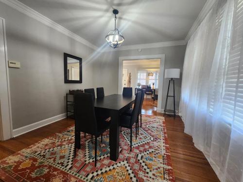 Un comedor con una mesa y sillas sobre una alfombra. en Katherine's Cozy Bungalow, en Terre Haute