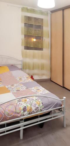 un lit dans une chambre avec une fenêtre dans l'établissement Appartement lumineux dans le centre de Digne-les-Bains avec balcon., à Digne-Les-Bains