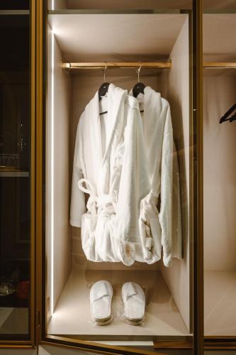 a closet with white towels and slippers in it at XVI Suites - Adults Only in Naxxar