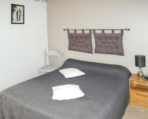 une chambre avec un lit avec deux oreillers dessus dans l'établissement Maison charmante à Sougéal avec superbe jardin, à Sougéal