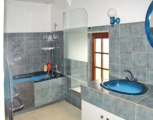 une salle de bain avec un lavabo bleu et une douche dans l'établissement Maison charmante à Sougéal avec superbe jardin, à Sougéal