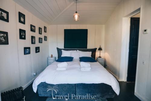 a bedroom with a large white bed with blue pillows at Villa Grand Marchais in Les Portes