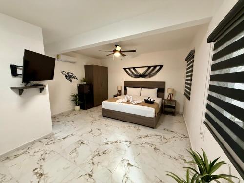 une chambre avec un lit et une télévision à écran plat dans l'établissement CASA TORTUGA 5Th Ave, à Playa del Carmen